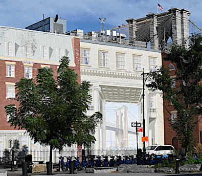 建物の向こうのブルックリンブリッジを描いた、ユーモアのある壁画